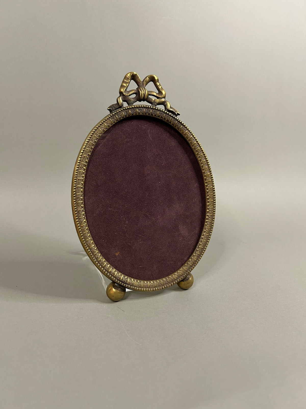 Brass bow oval frame
