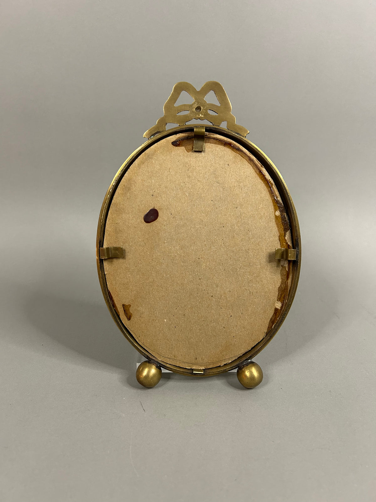 Brass bow oval frame